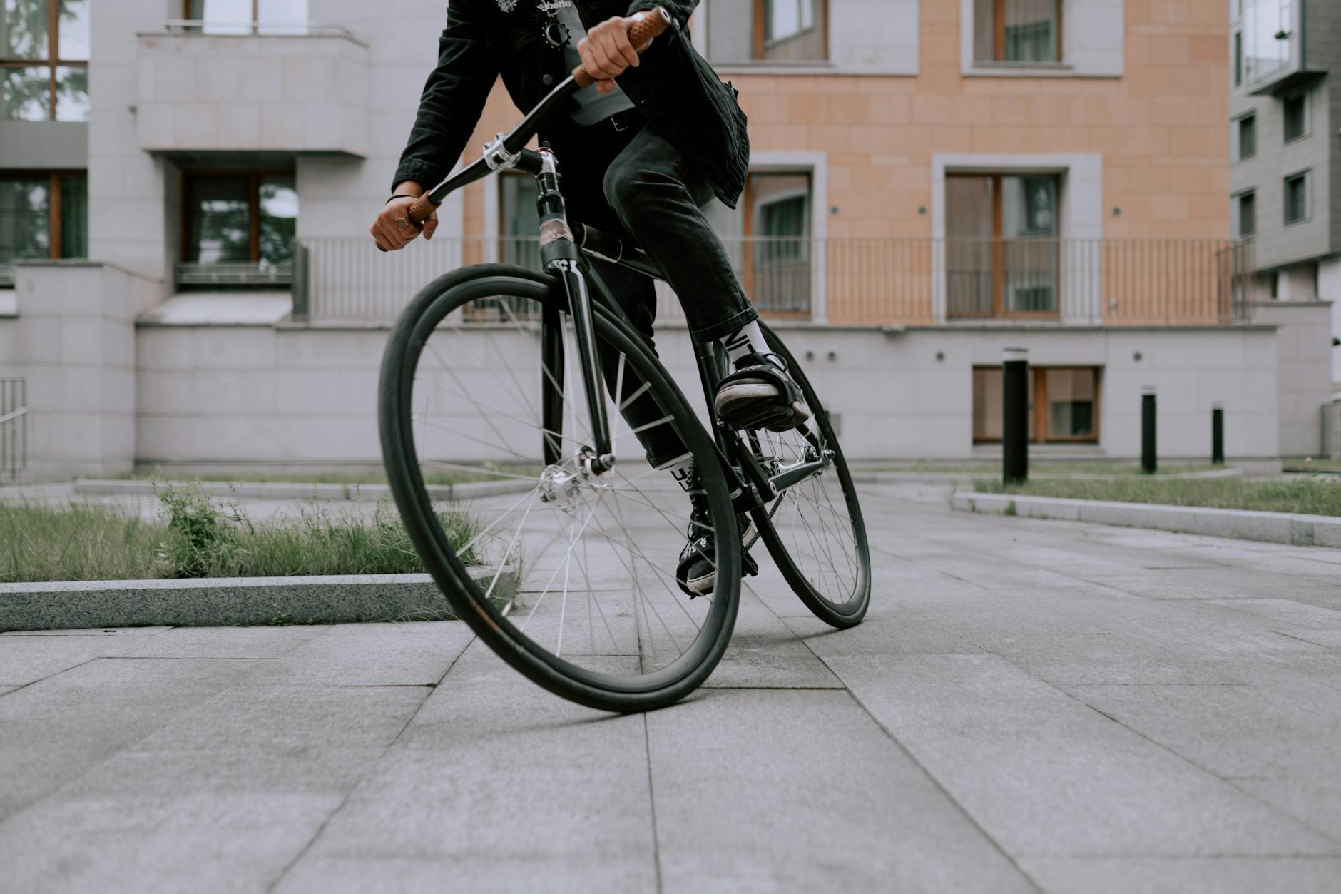 A fashionable cyclist performing a sharp turn on a city street, showcasing agility and style.