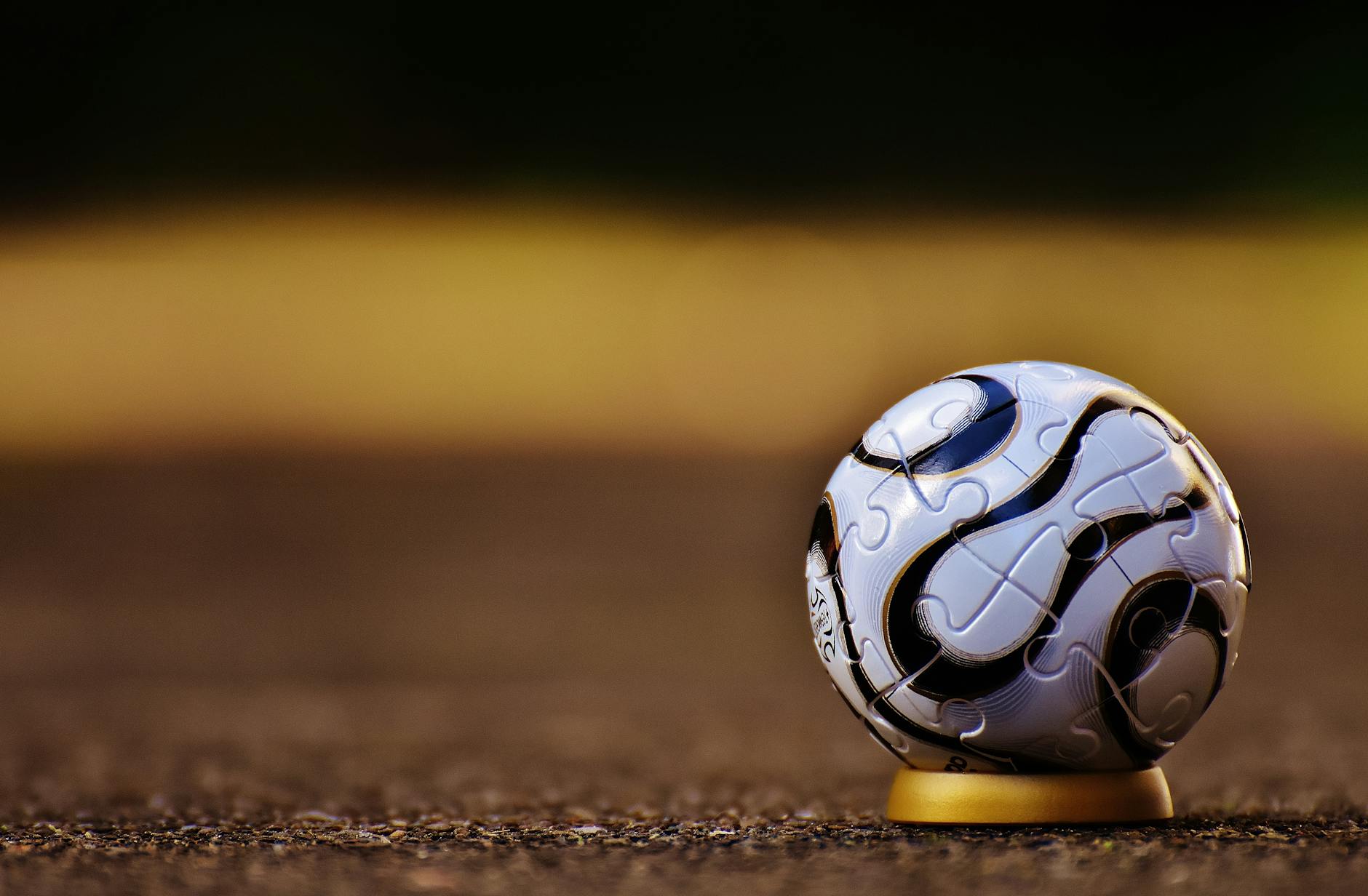 A close-up shot of a spherical puzzle ball placed on an outdoor surface, showcasing intricate patterns.