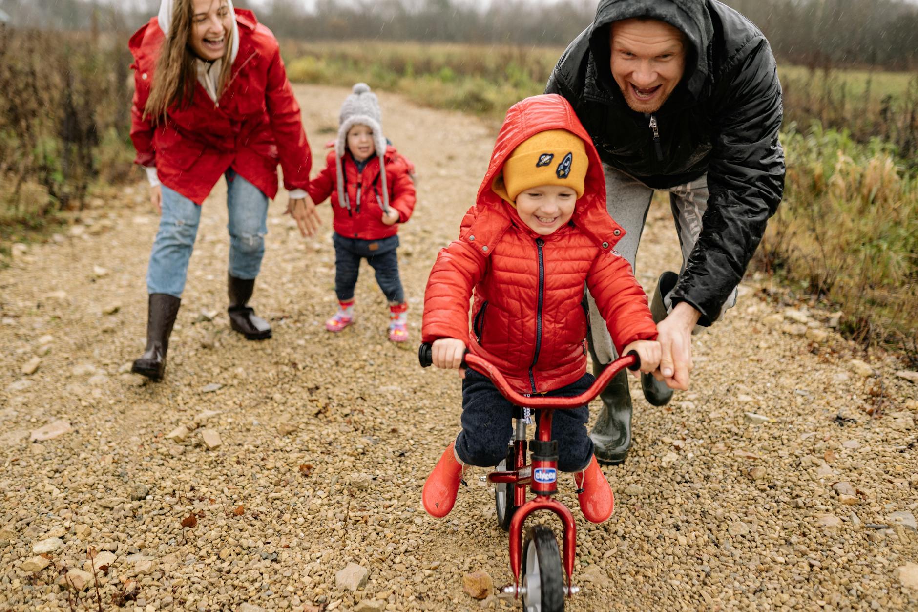 Parents teaching kids to ride bikes outdoors in fall, enjoying family bonding and fun.